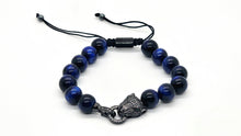 Load image into Gallery viewer, A blue tiger eye beaded stretch bracelet featuring a black sophisticate leopard head charm.Adorned with dark blue round beads, a black cord with sliding knots, with small rhinestones an adjustable drawstring closure.