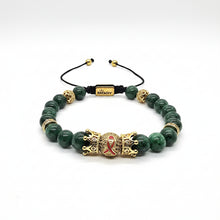 Load image into Gallery viewer, A beaded stretch bracelet featuring dark green marbled beads, gold-toned spacer beads, a black adjustable cord, and a central gold crown charm with red enamel details. The brand name 'BIMODY' is visible on a small gold tag on the cord.

