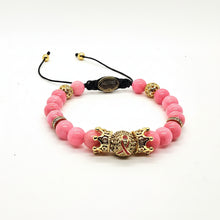 Load image into Gallery viewer, A pink beaded bracelet with a central gold-toned dragon charm, decorative gold spacer beads, and a black adjustable cord closure on a white background.
